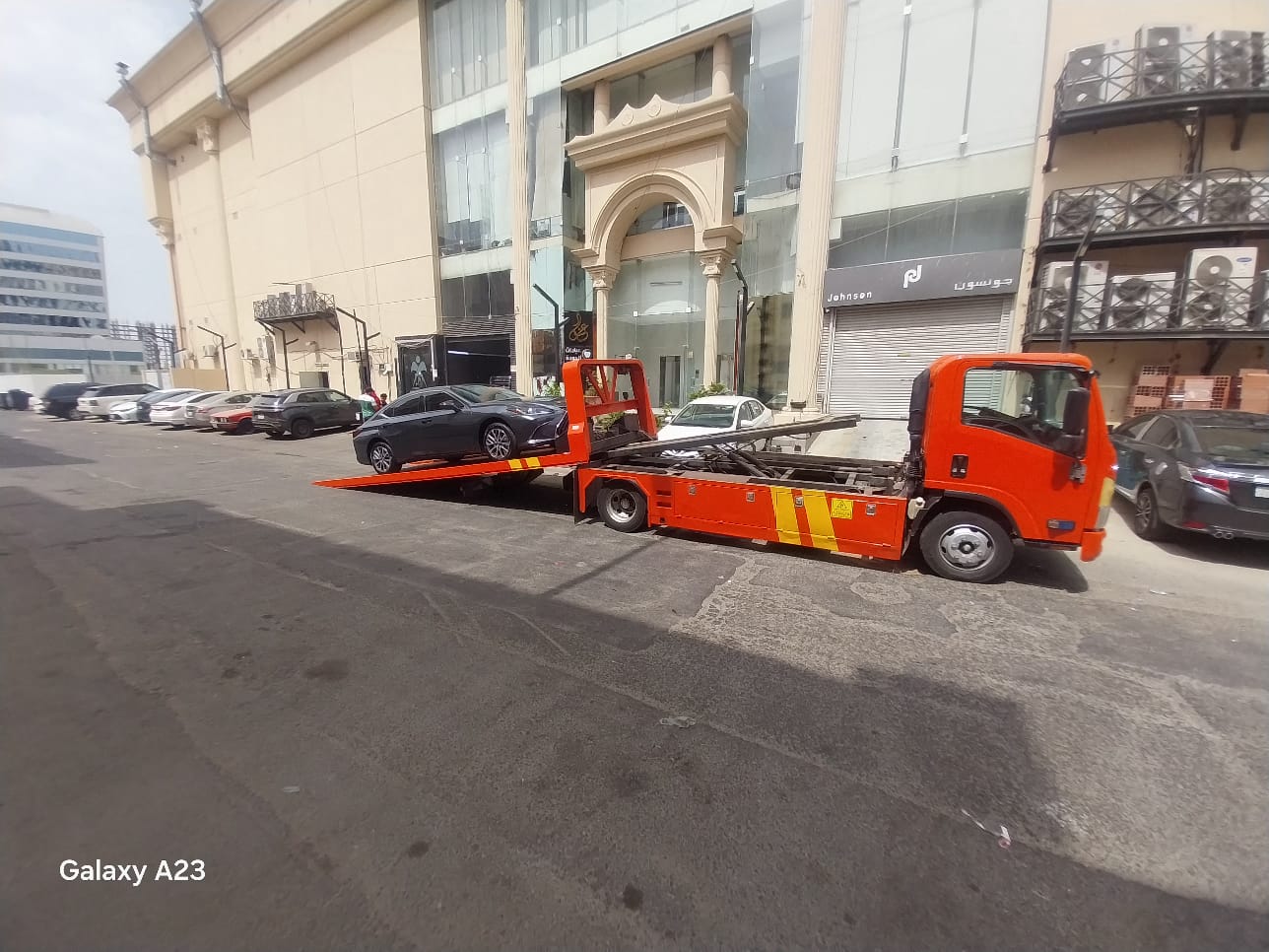 سطحة الدمام تنقل سيارة في شارع تجاري