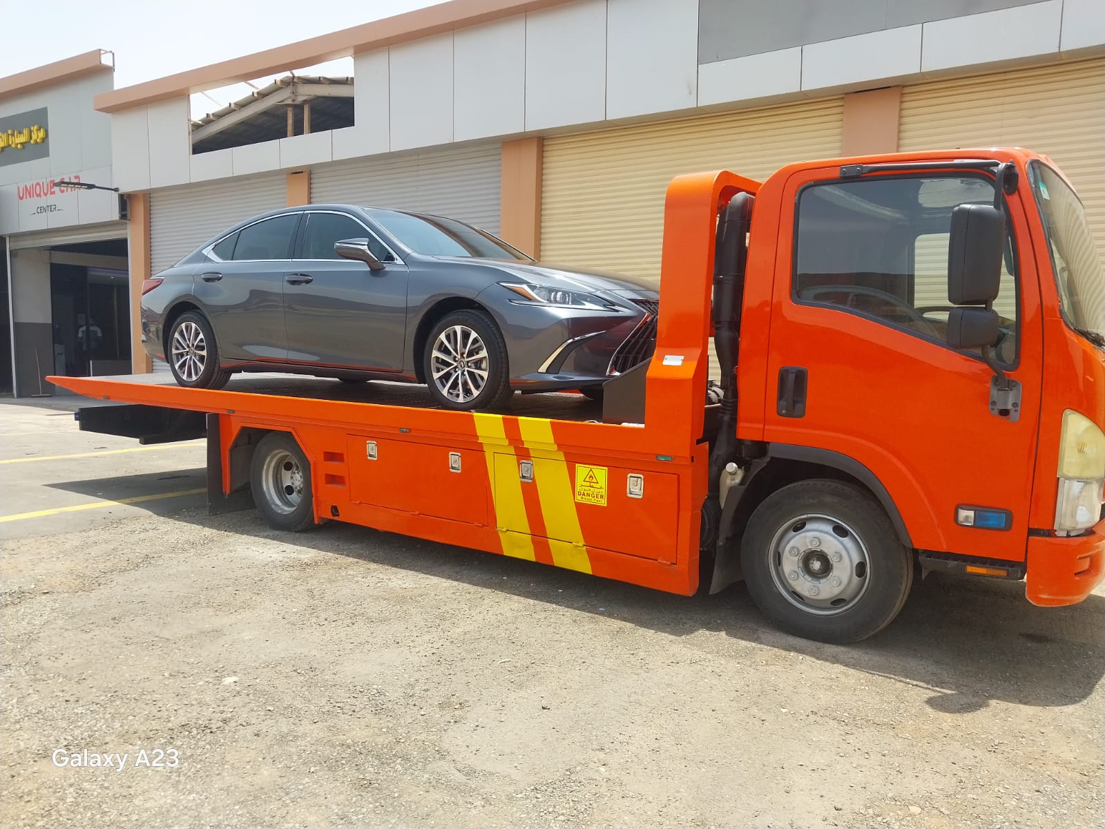 سطحة الدمام تنقل سيارة أمام مبنى تجاري